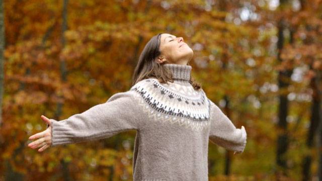 donna passeggia nel bosco per alleviare lo stress in autunno